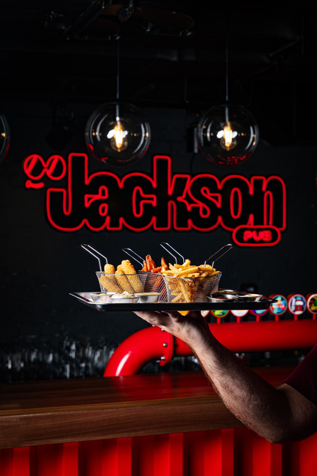 Konobar nosi tacnu sa hranom ispod Jackson neonskog znaka